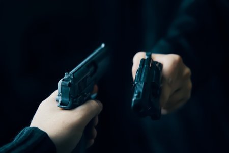 169668264-manos-de-dos-hombres-con-armas-apuntándose-el-uno-al-otro-tiroteo-con-armas-de-fuego-de-dos